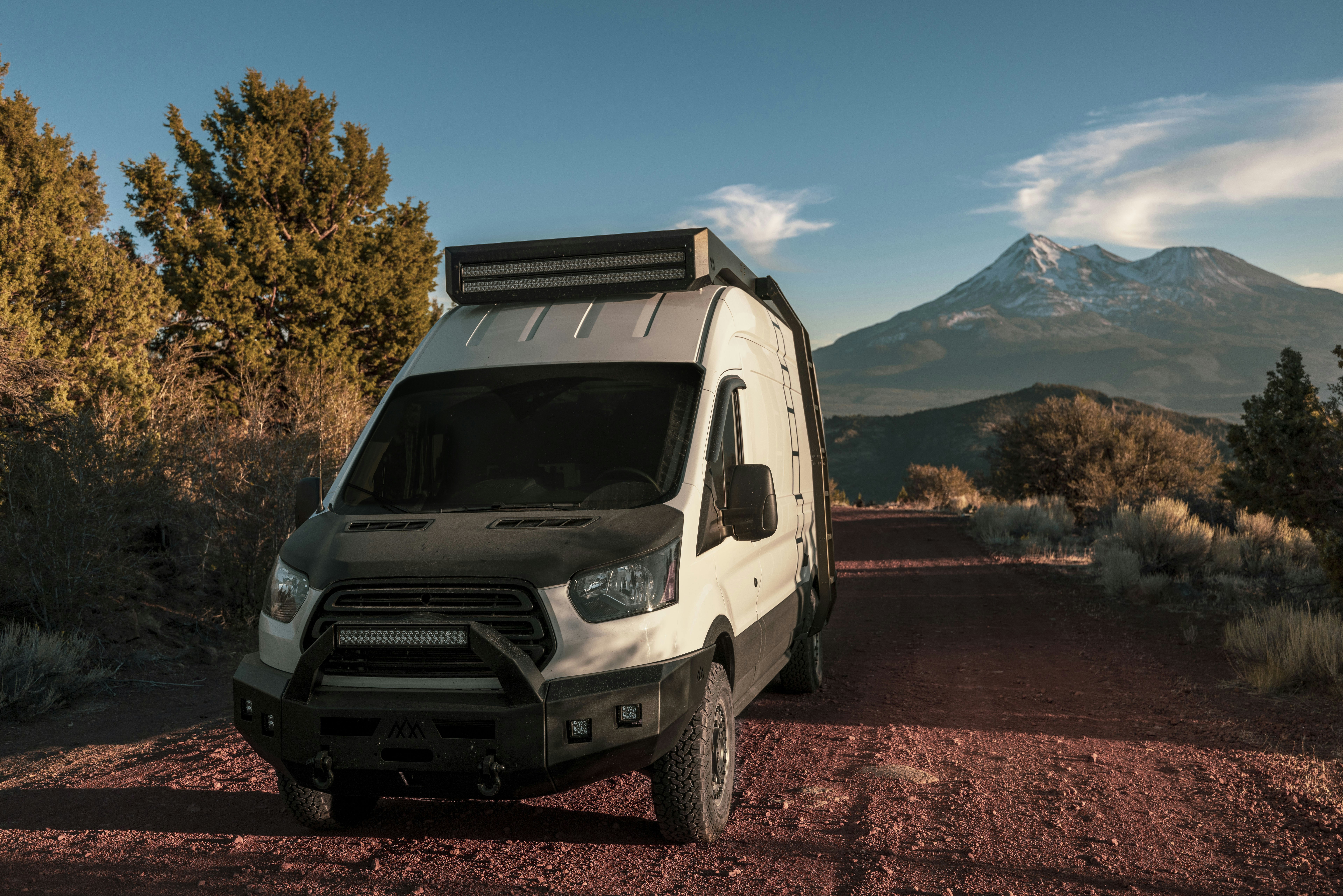 a white van is parked on a dirt road