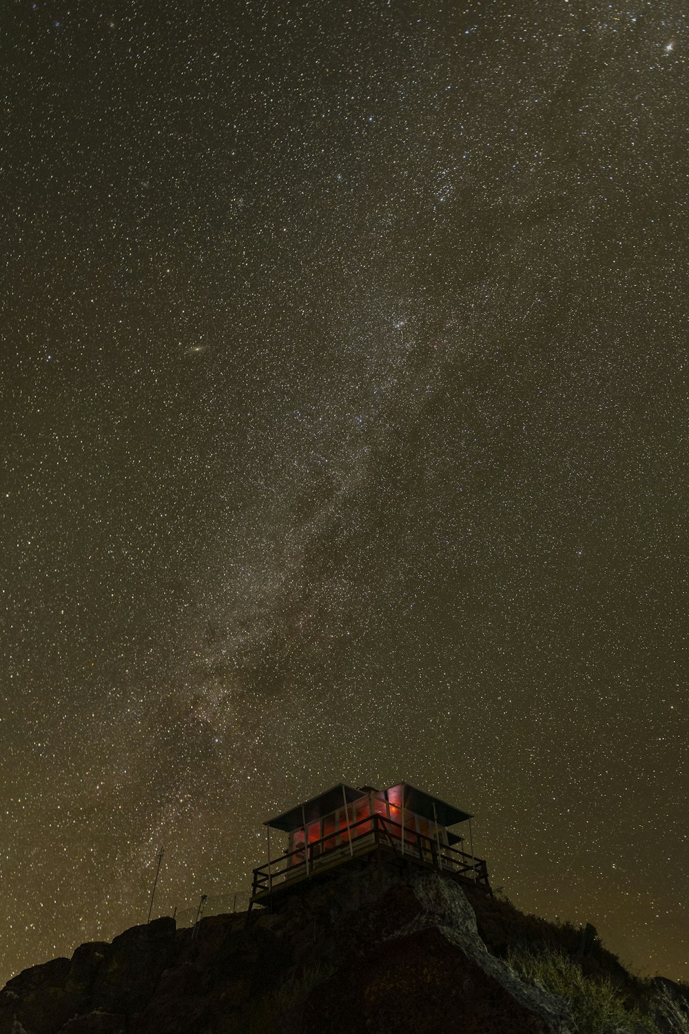 a building on top of a hill under a night sky