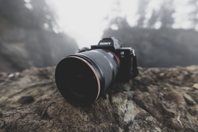 a camera sitting on top of a rock