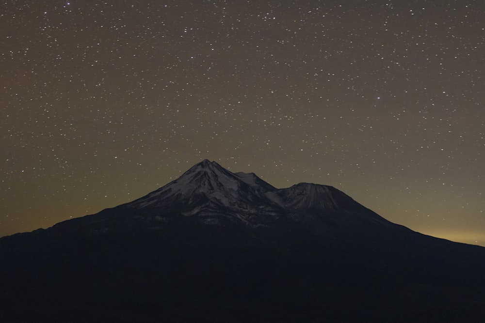 the night sky is filled with stars above a mountain