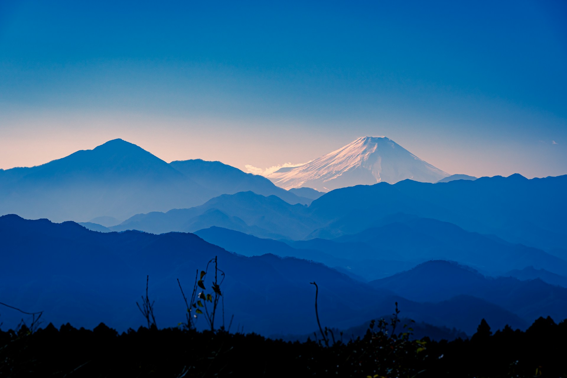 A stunning mountain landscape with snow-capped peaks and a clear blue sky.