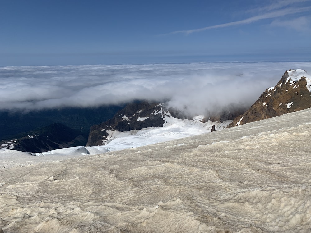 a view of a mountain with snow and clouds