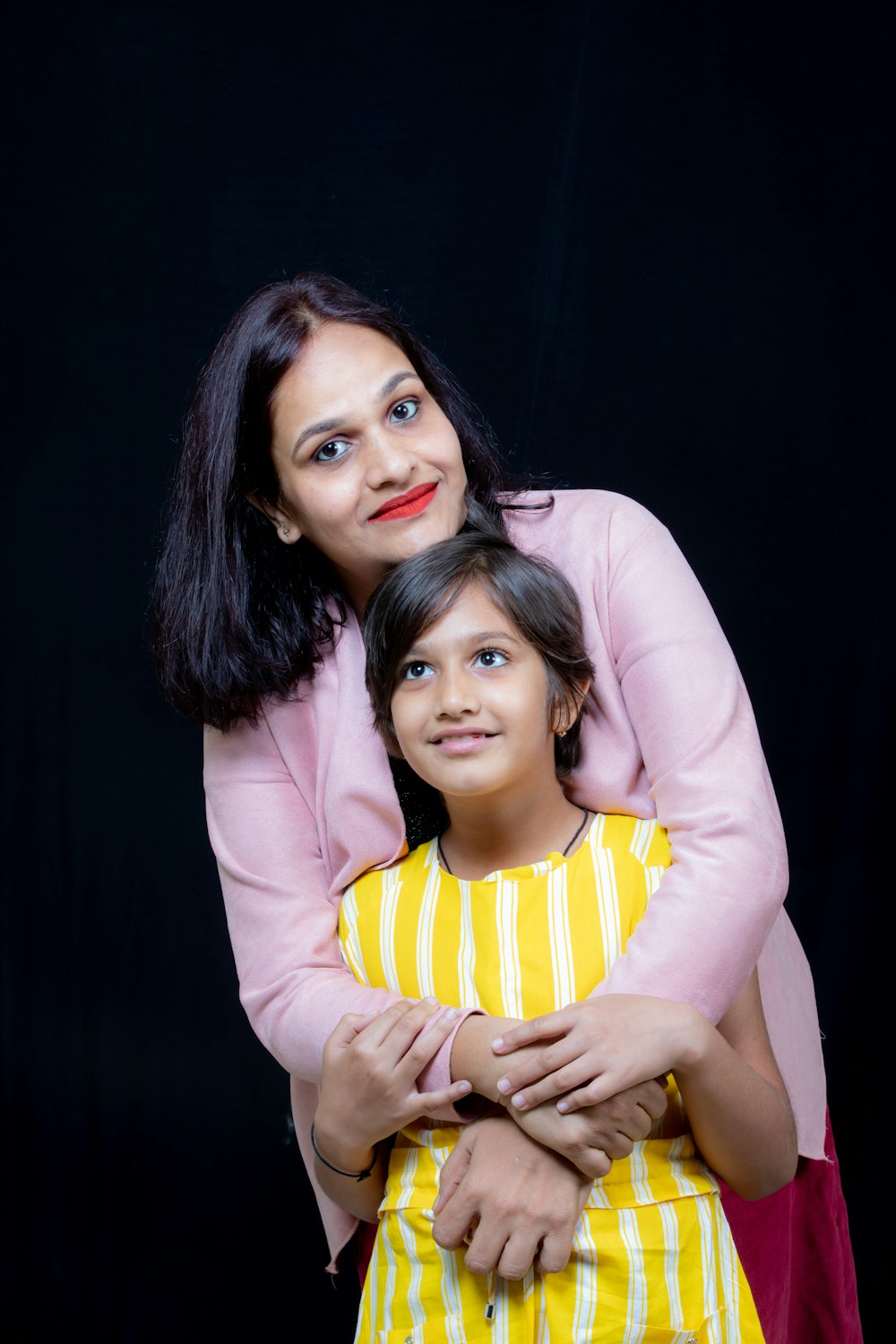 a woman holding a little girl in her arms