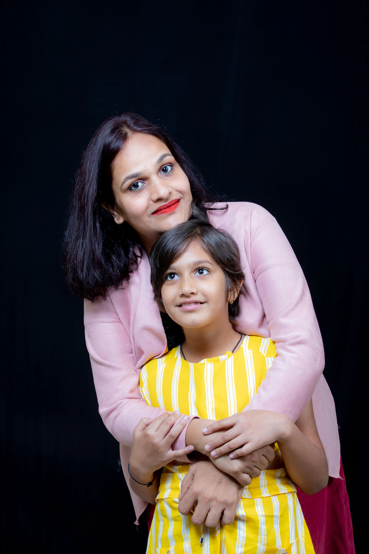 A mother hugging her young daughter