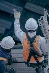 two men in safety gear sitting on a bench