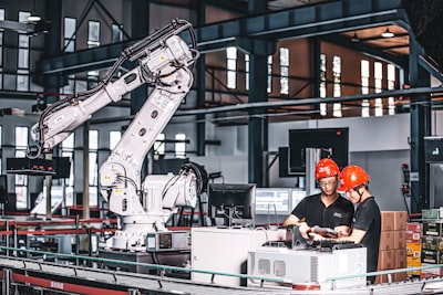 People controlling a robot at a manufacturing facility