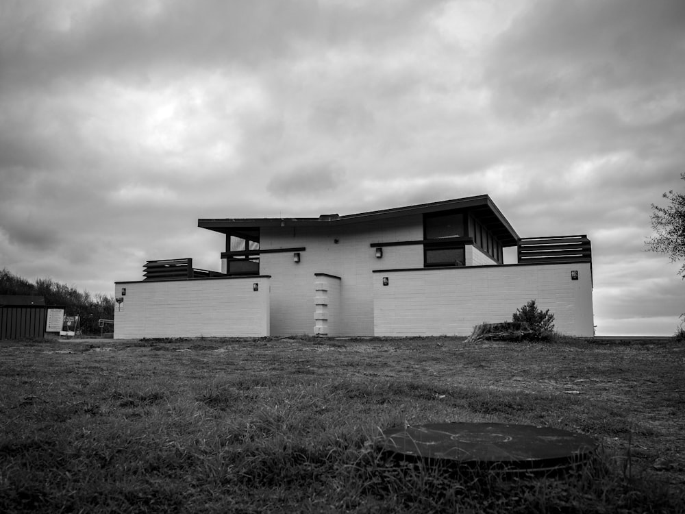a black and white photo of a house on a cloudy day