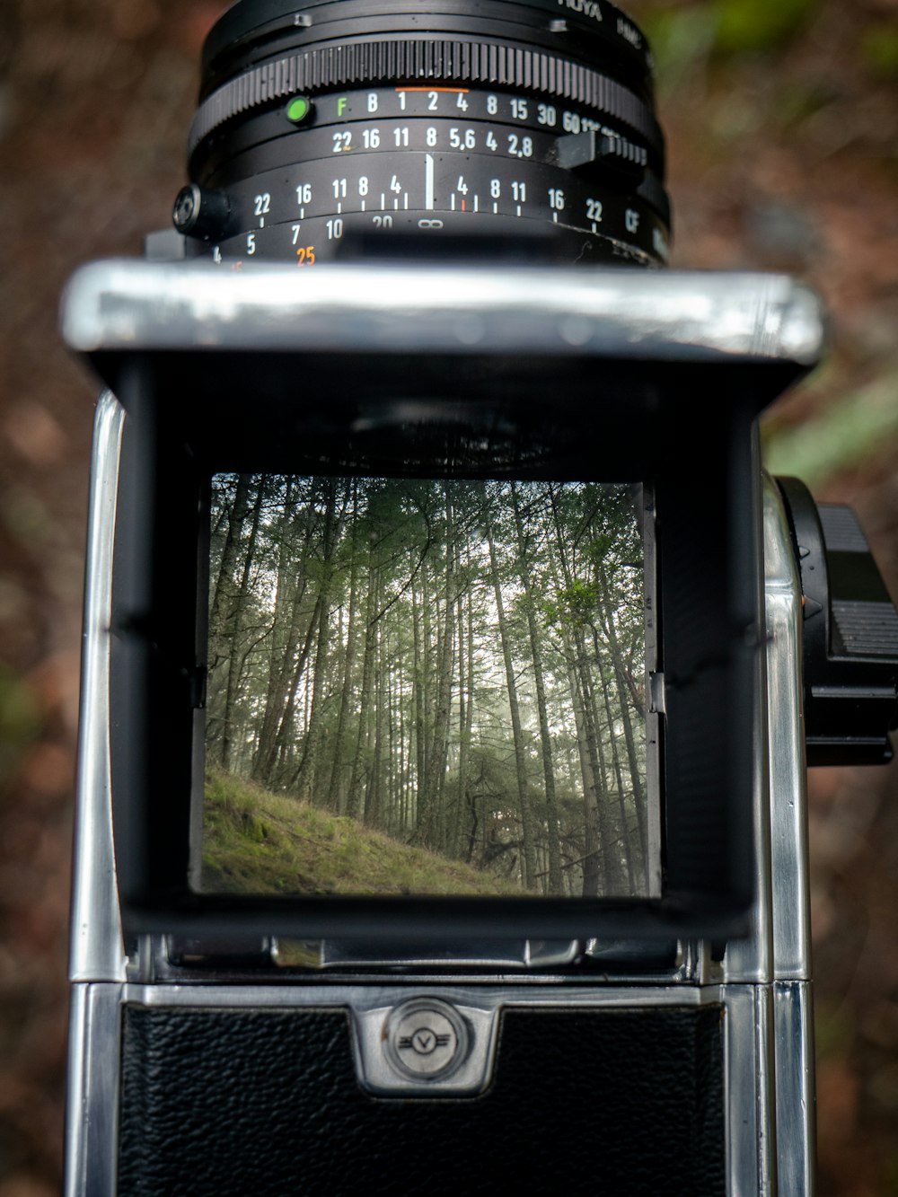 a close up of a camera with trees in the background