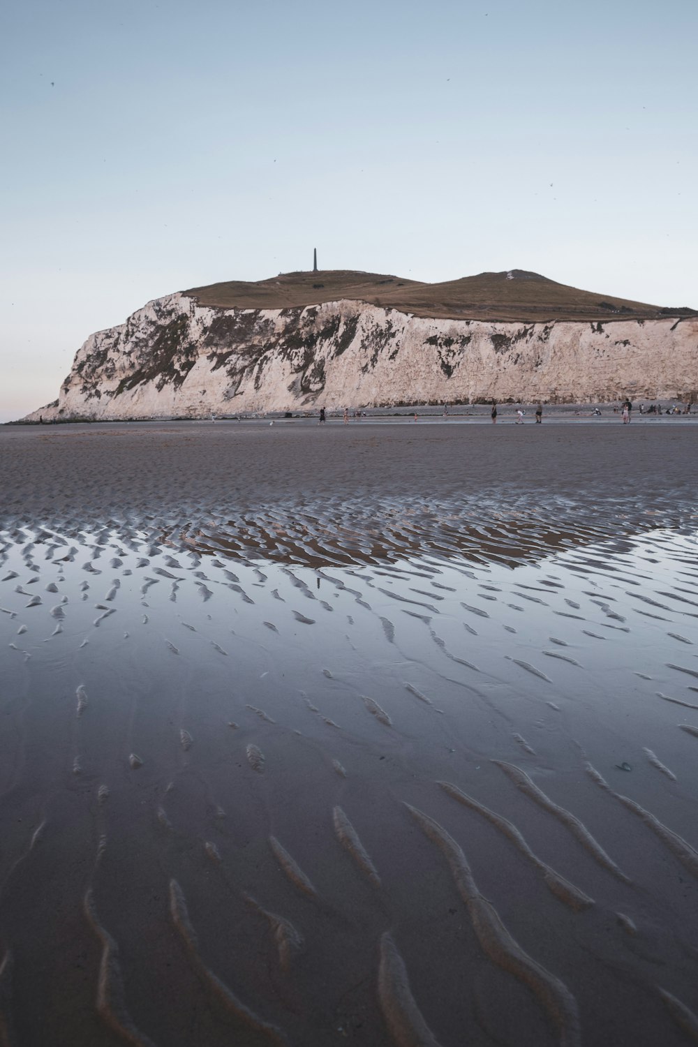 a group of people standing on top of a sandy beach