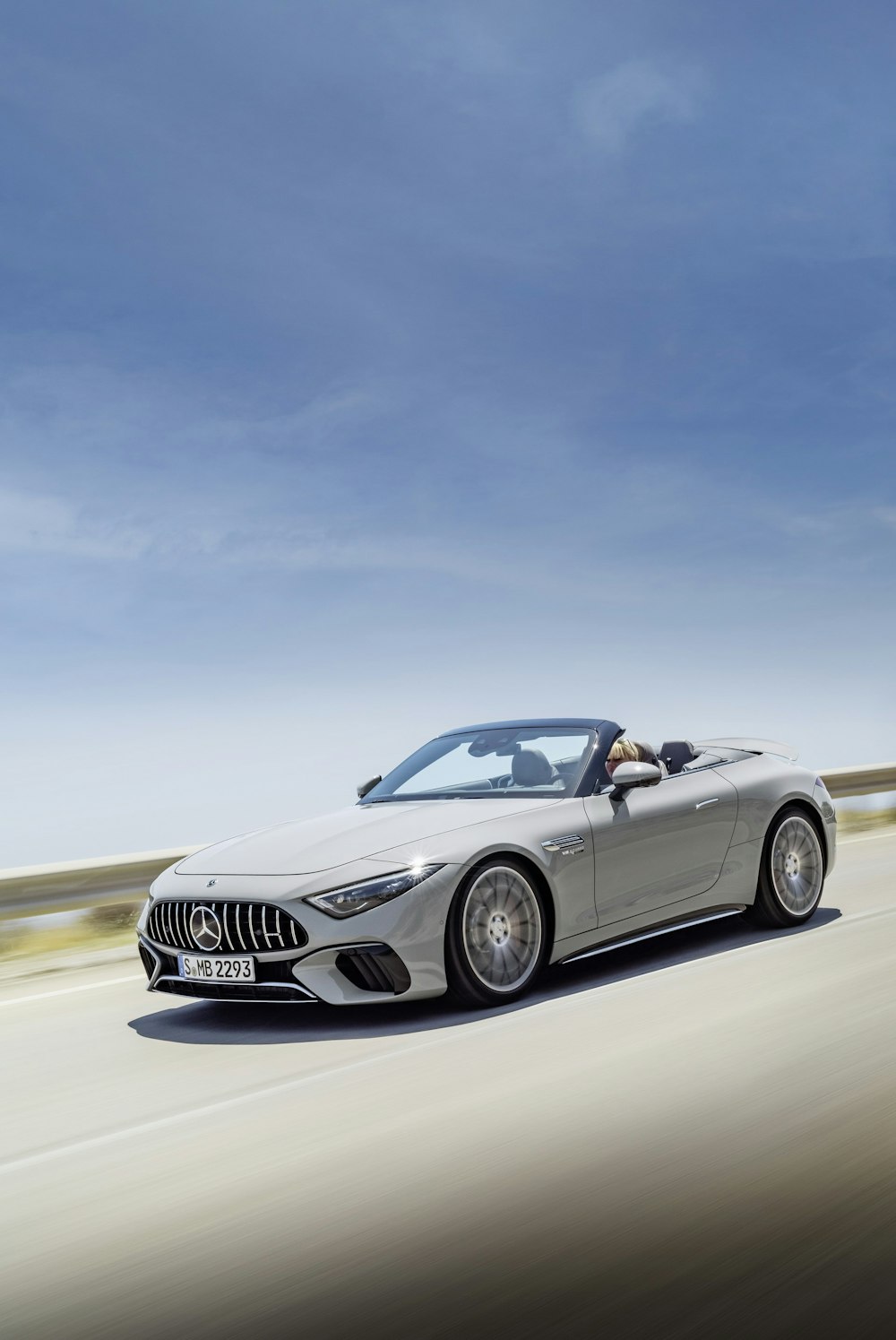 a silver convertible car driving down a highway