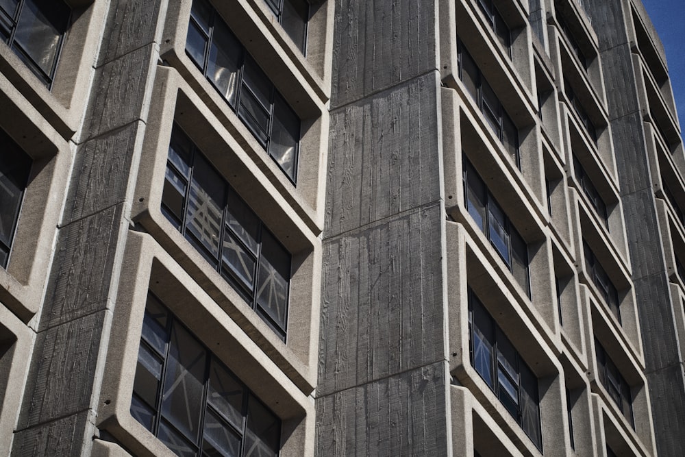 a tall building with lots of windows next to a blue sky