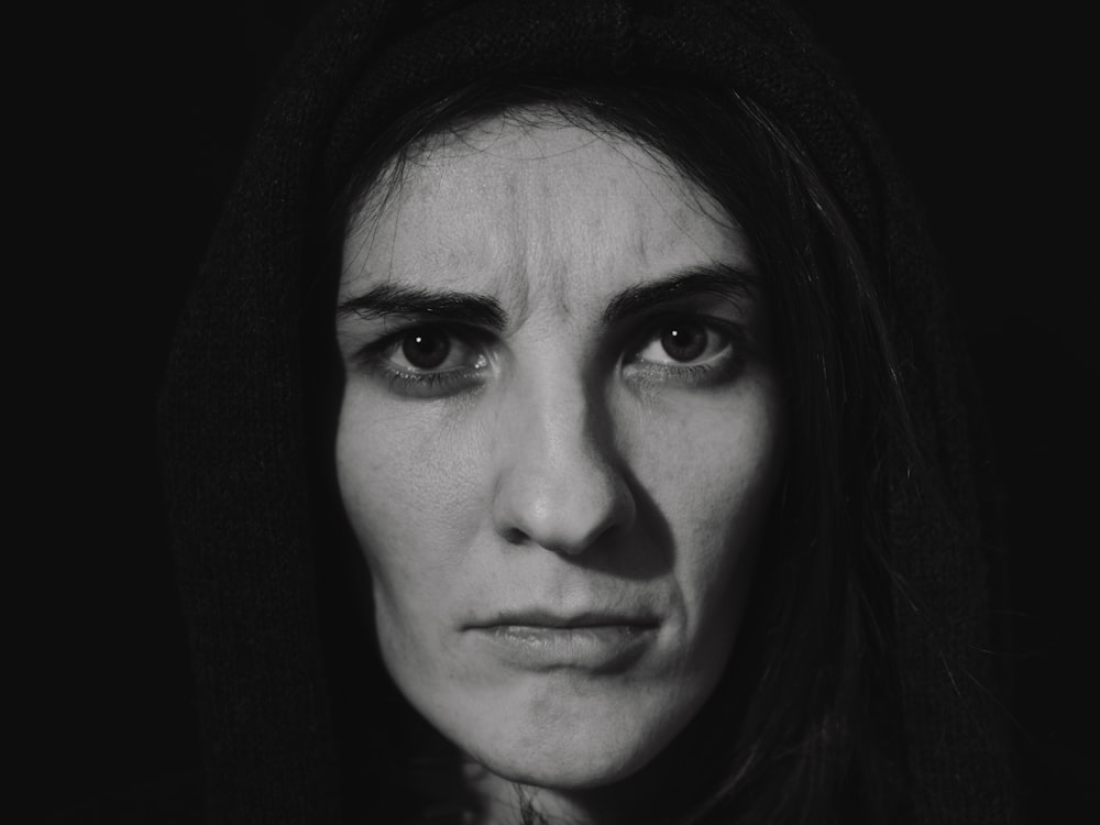 a black and white photo of a woman wearing a hoodie