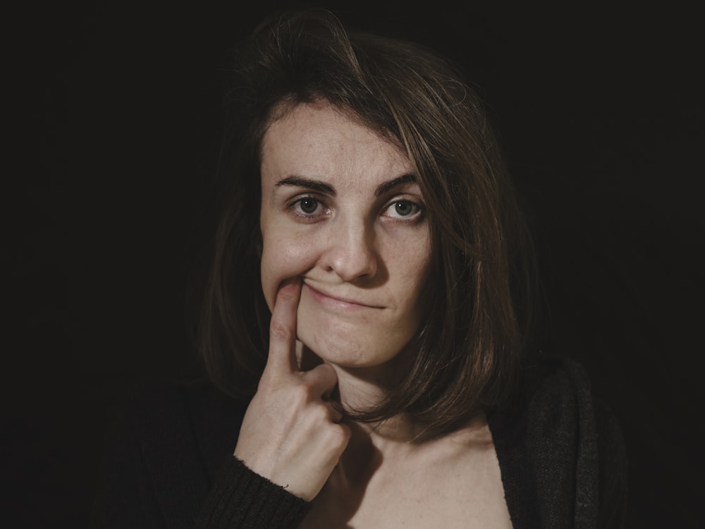 a woman posing for a picture with her hand on her chin