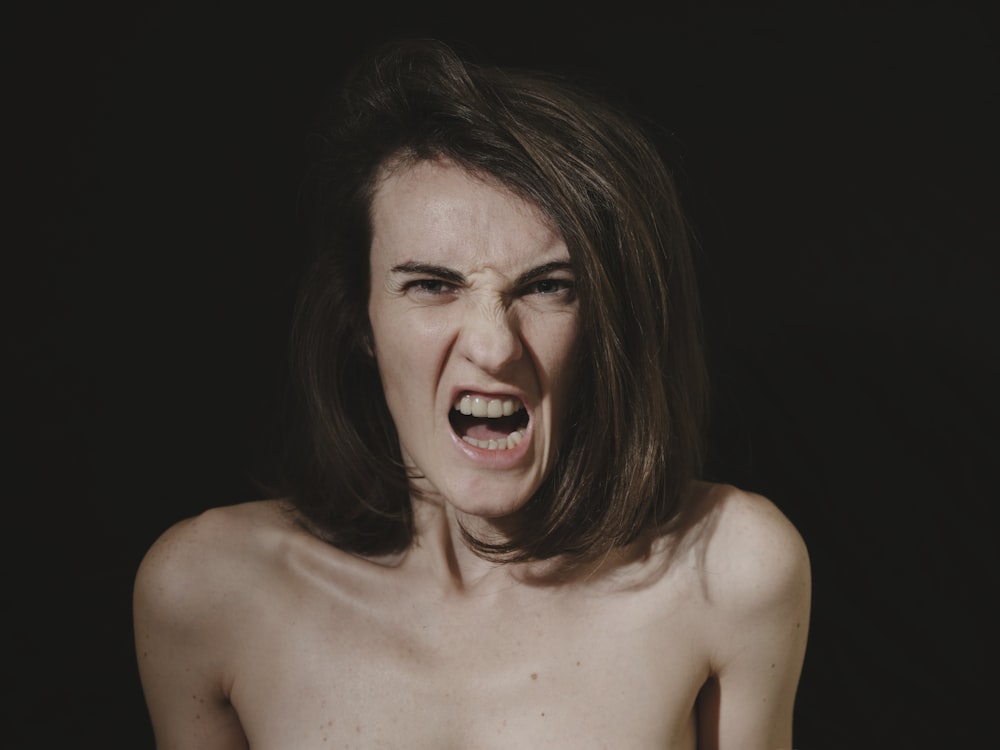a shirtless woman with her mouth open
