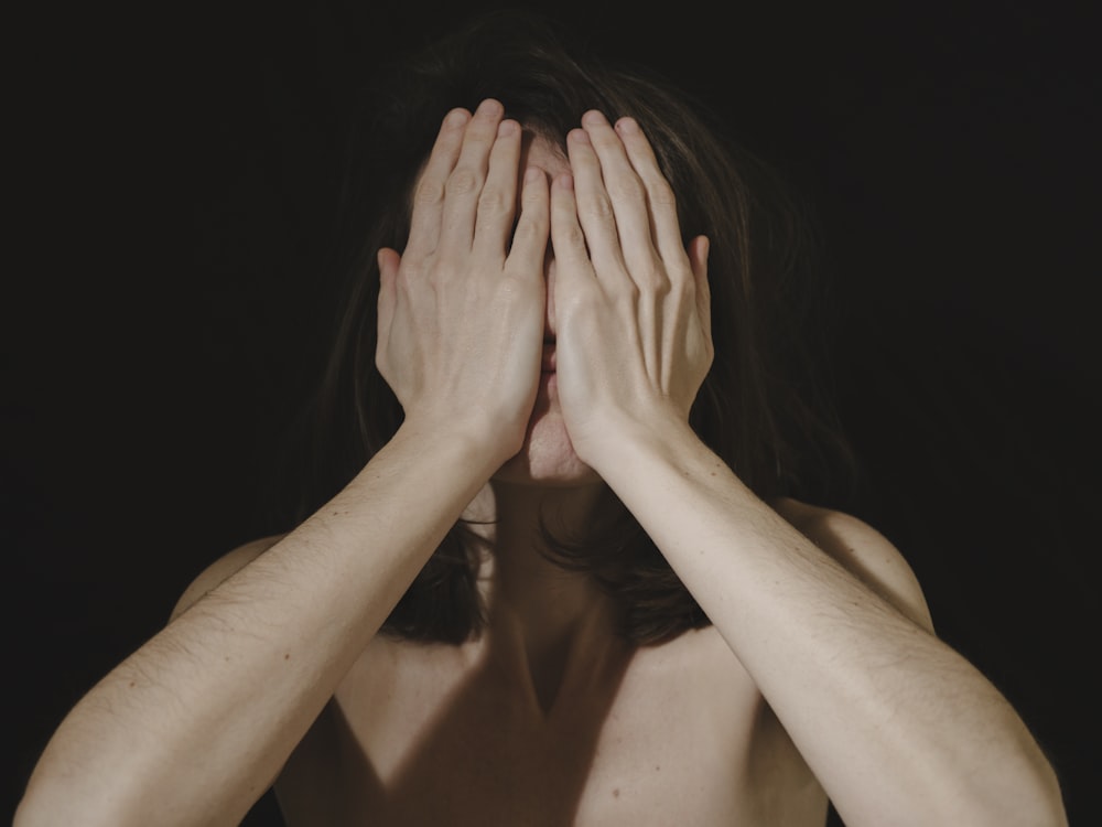 a woman covering her face with her hands