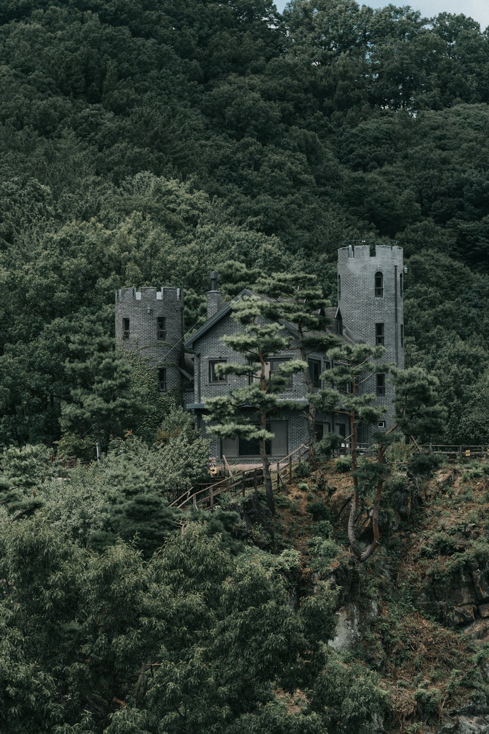 a large castle like building sitting on top of a lush green hillside