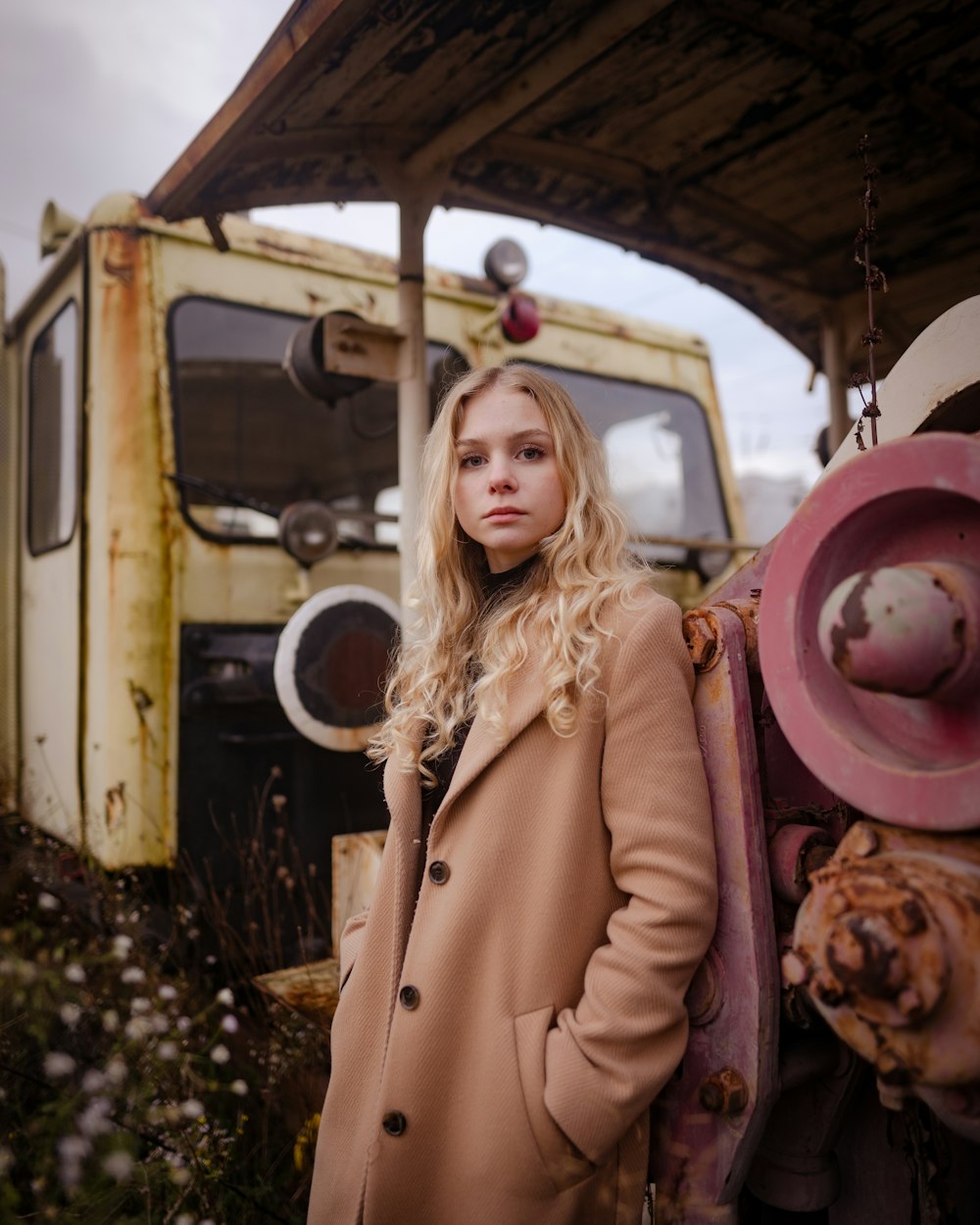 a woman standing in front of an old truck