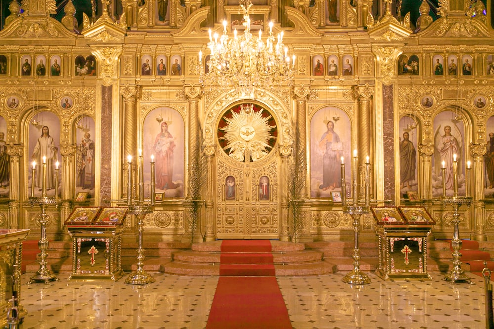 a church with a chandelier and a red carpet