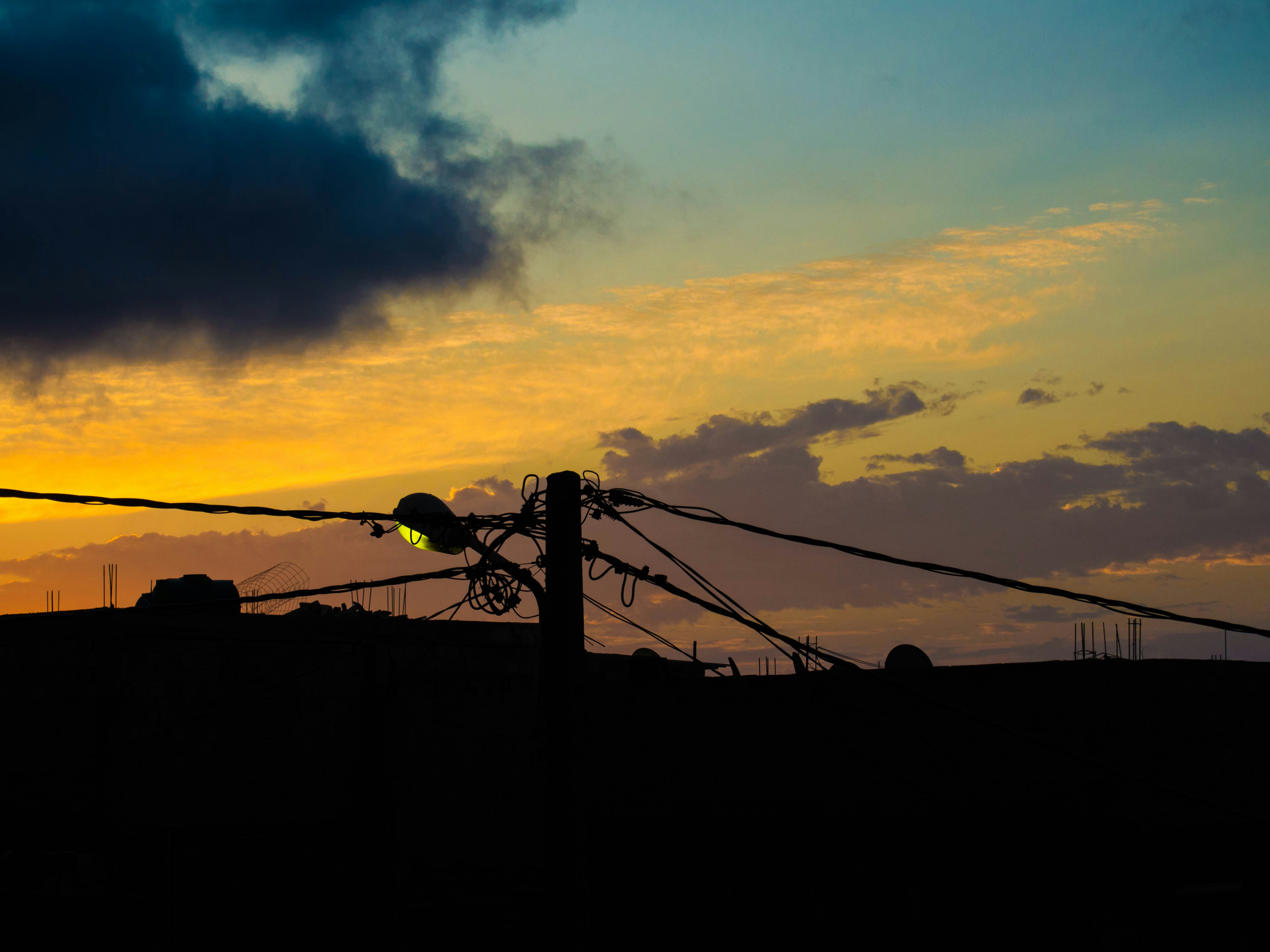 The sun is setting behind a barbed wire fence photo – Free Silhouette ...