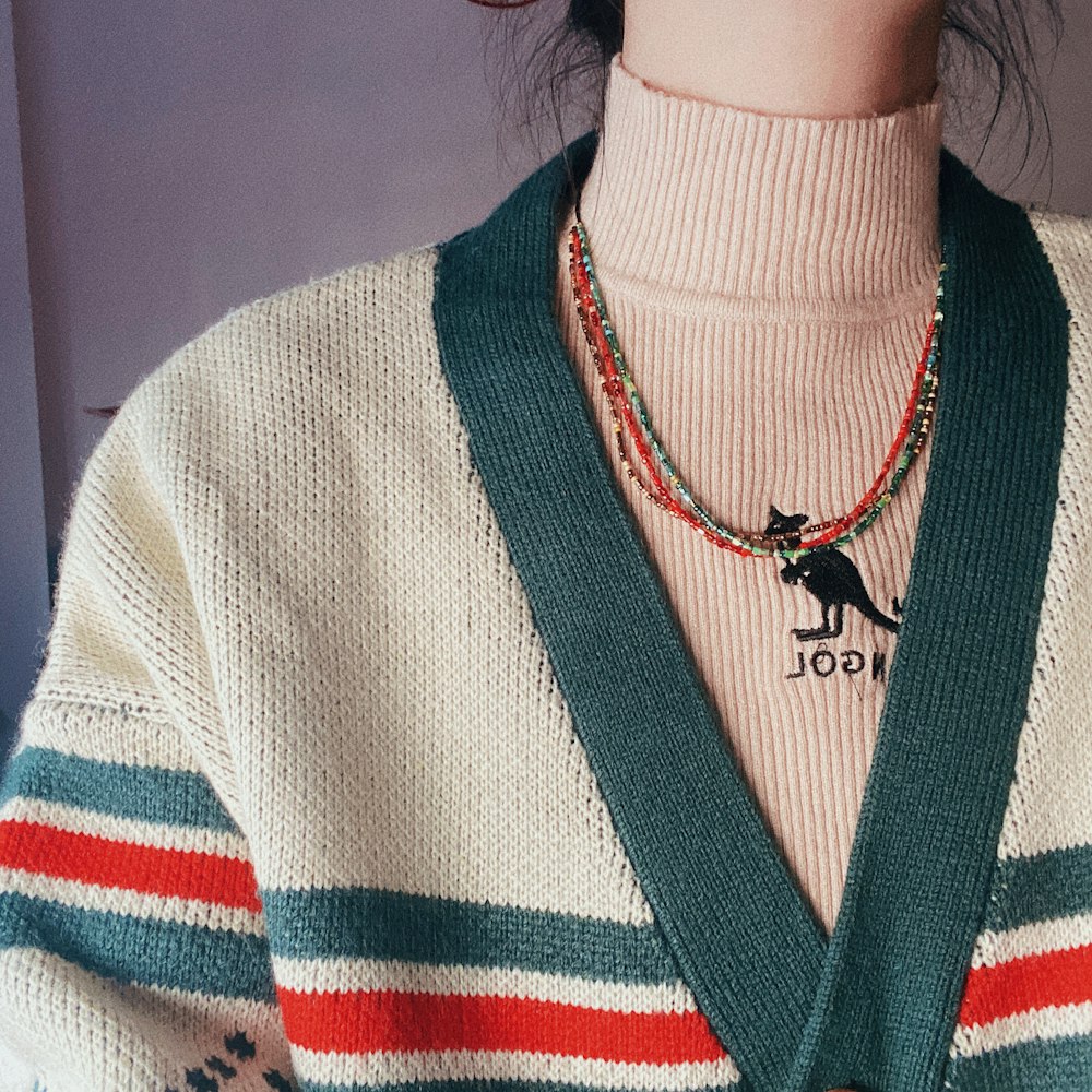 a person wearing a sweater and a necklace