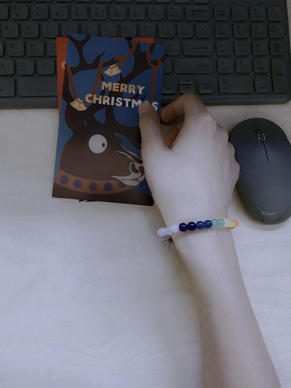 a person holding a book near a computer keyboard