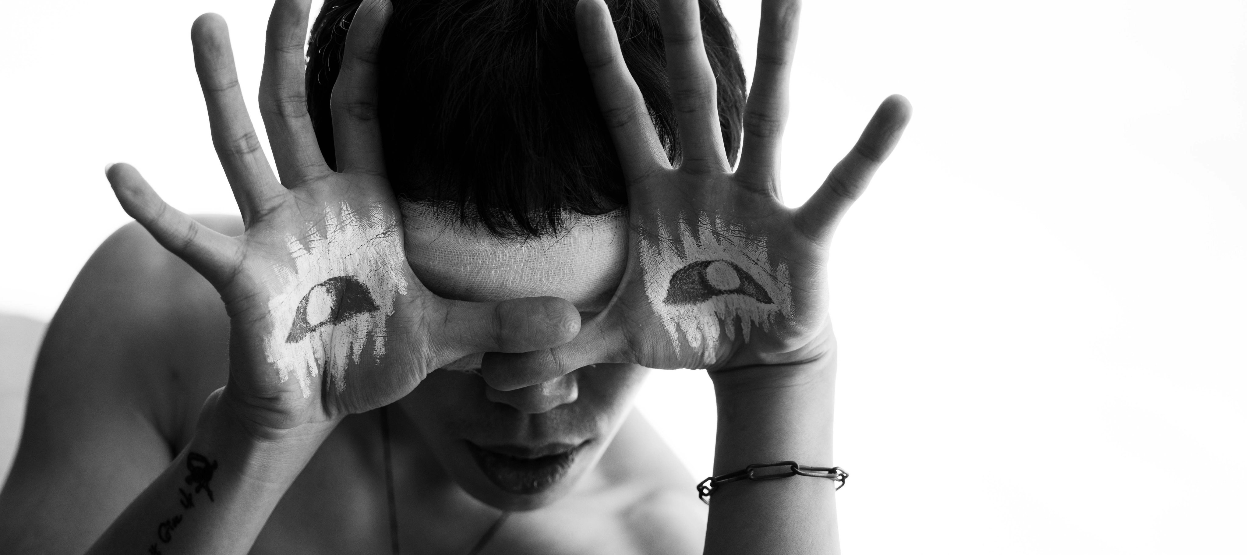 a woman with painted hands covering her face