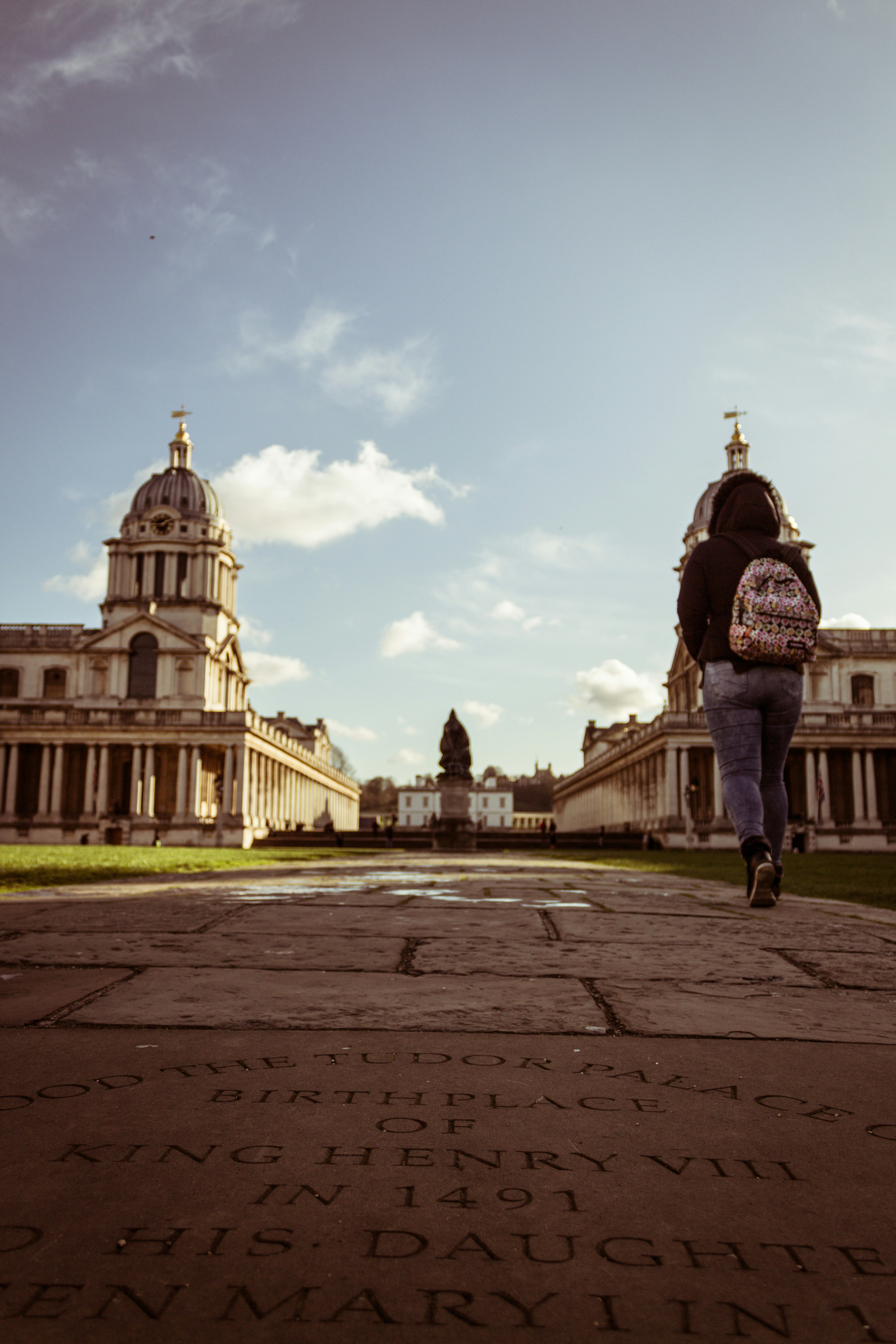 a woman walking down a sidewalk in front of a building