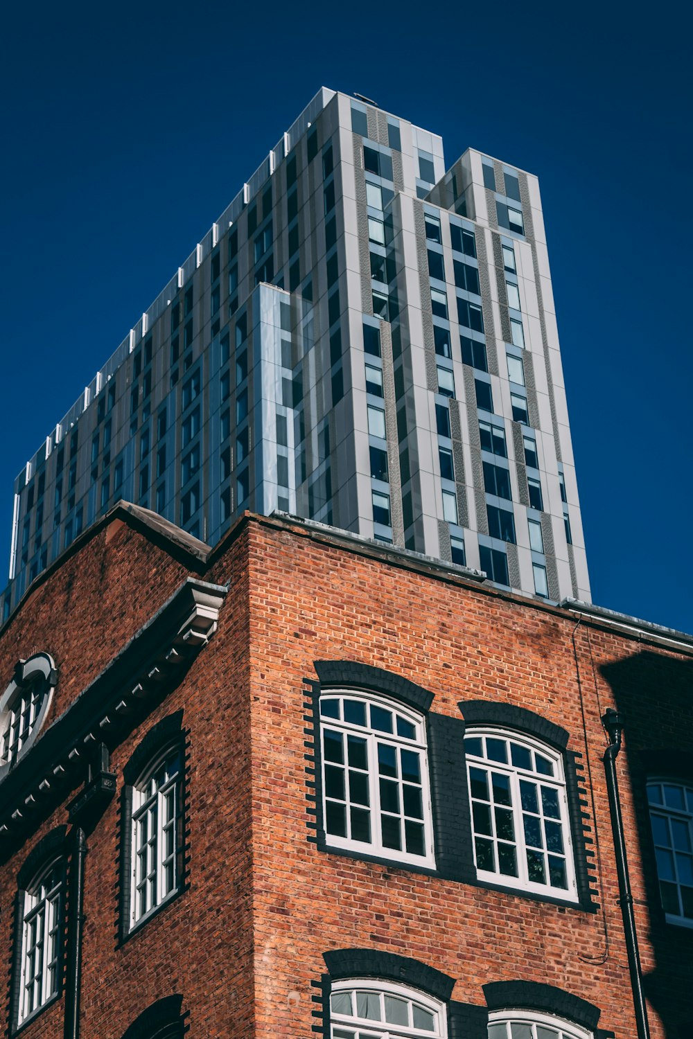 a tall brick building with a clock on it's side