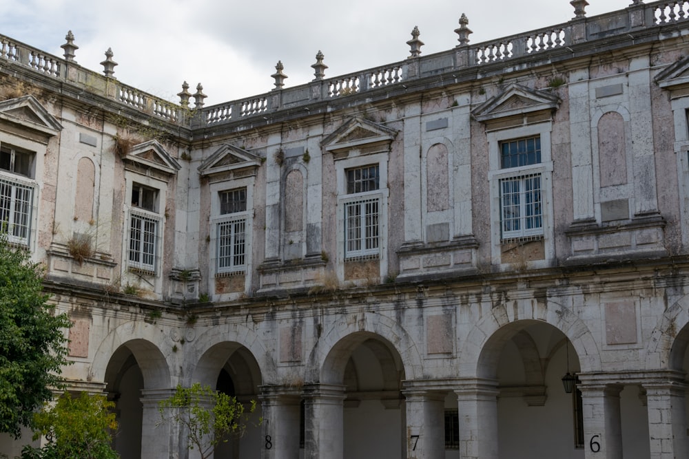 an old building with arches and a clock on the front of it