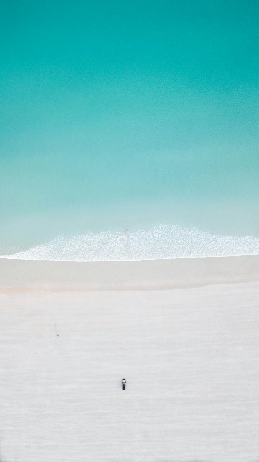 a person riding a surfboard on a sandy beach