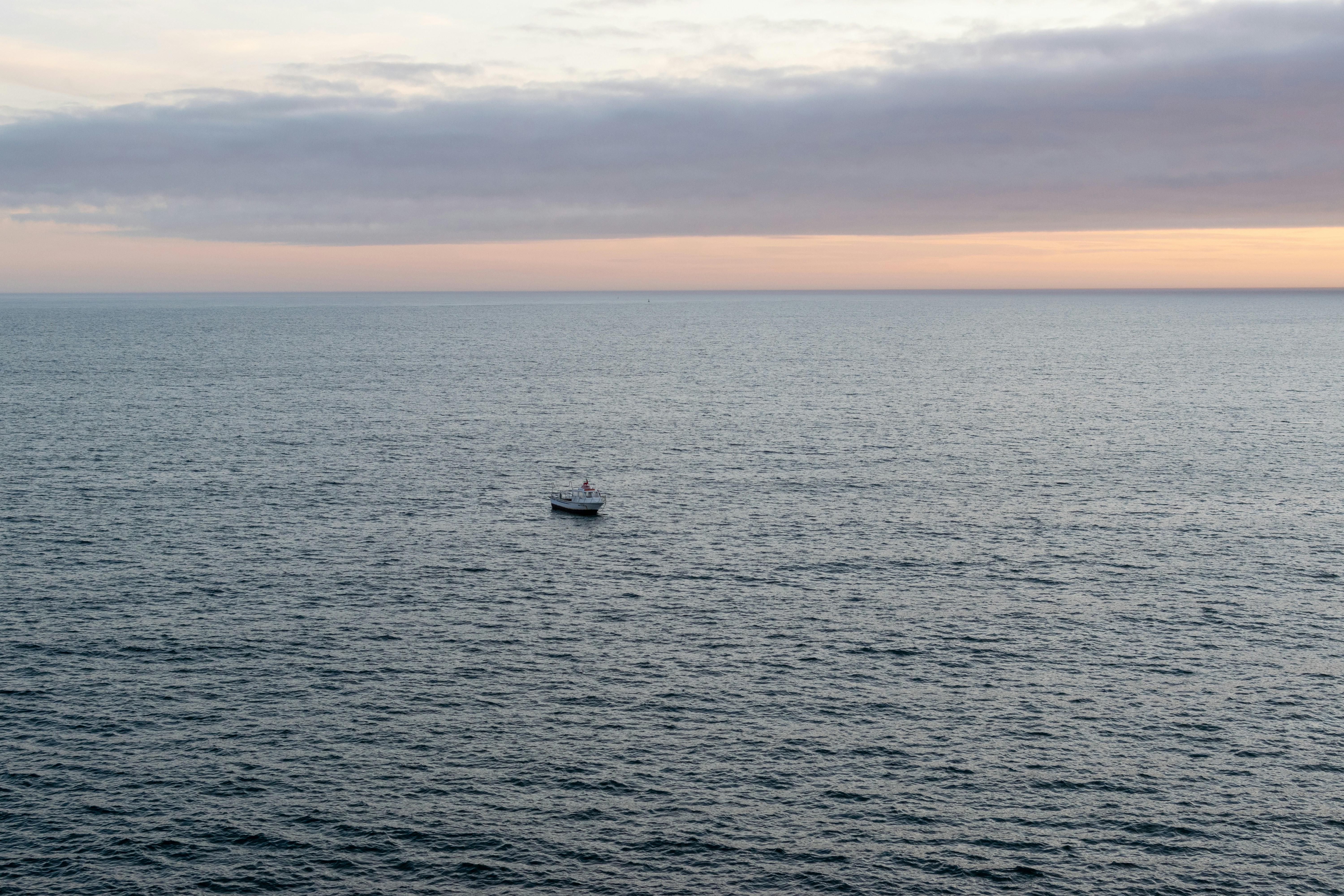 Un pequeño bote flotando sobre un gran cuerpo de agua