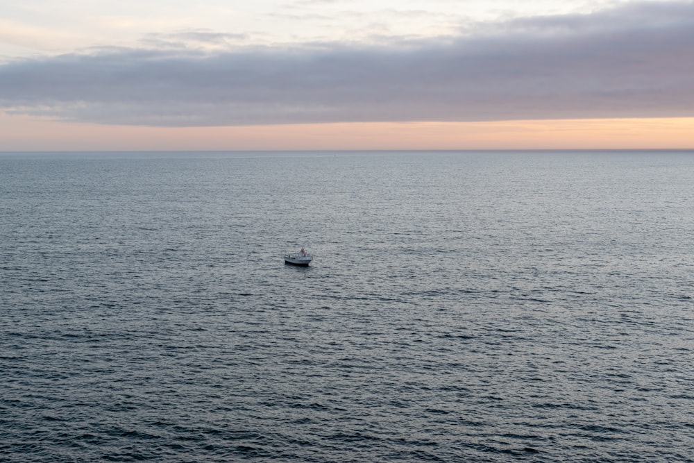 a small boat floating on top of a large body of water