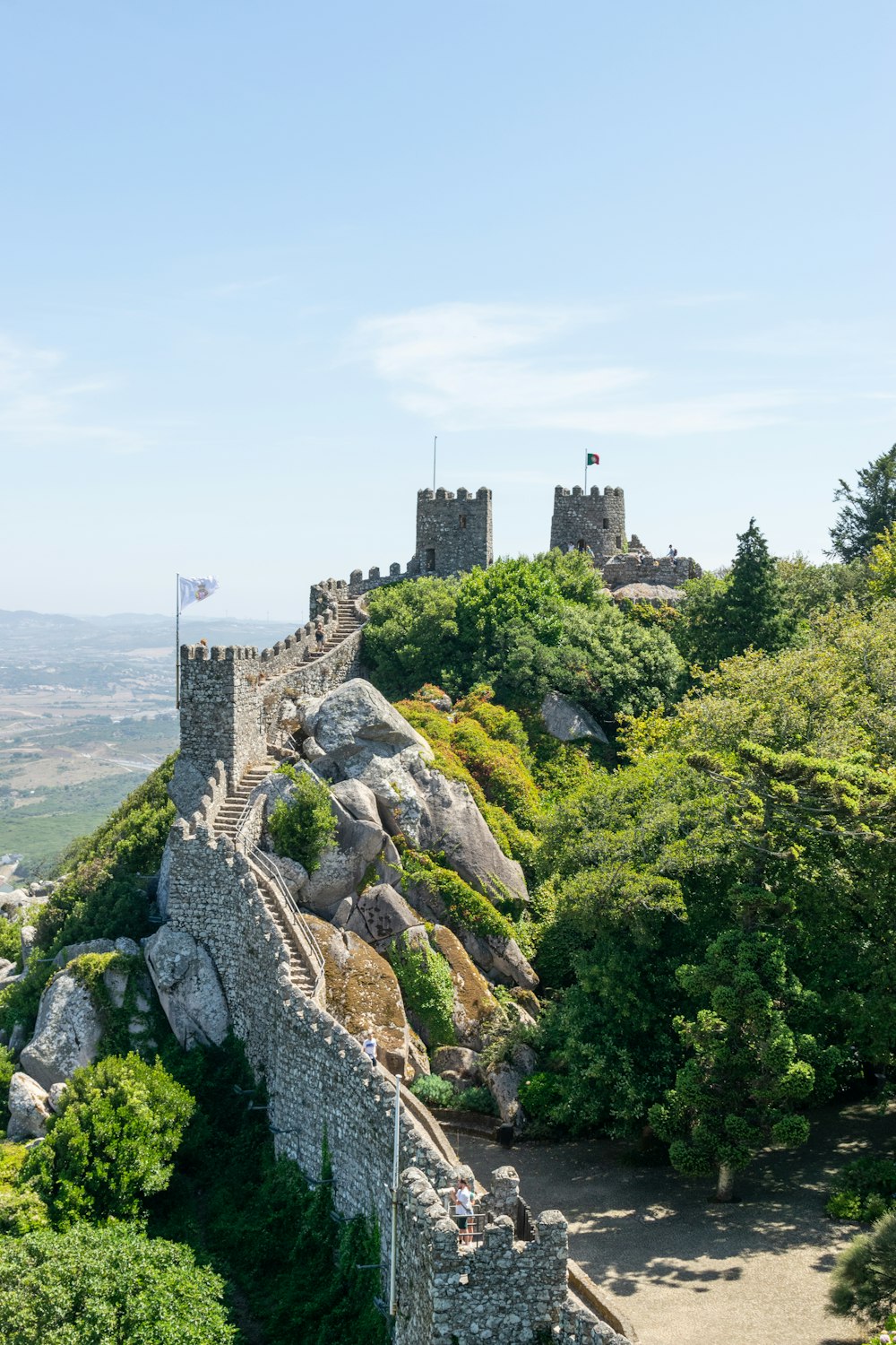 a very tall castle sitting on top of a lush green hillside