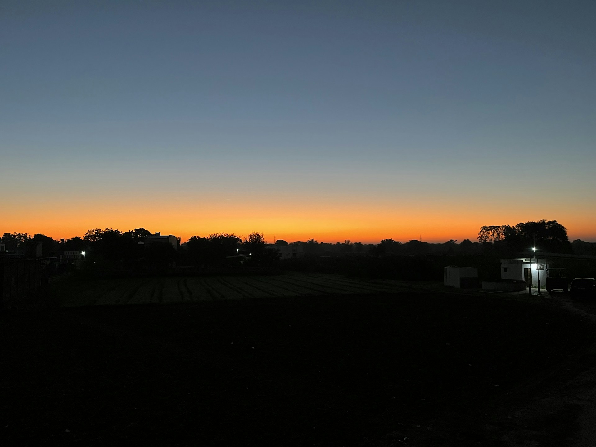 A cinematic landscape at twilight, where the fading light casts a golden glow on a serene, shadowed horizon.