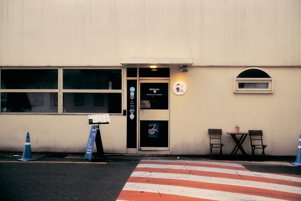 a white building with a black door and some blue cones