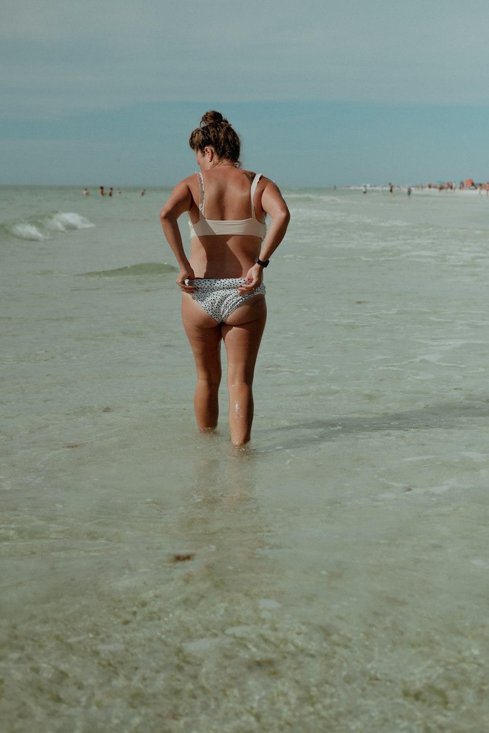 a woman standing in the water at the beach