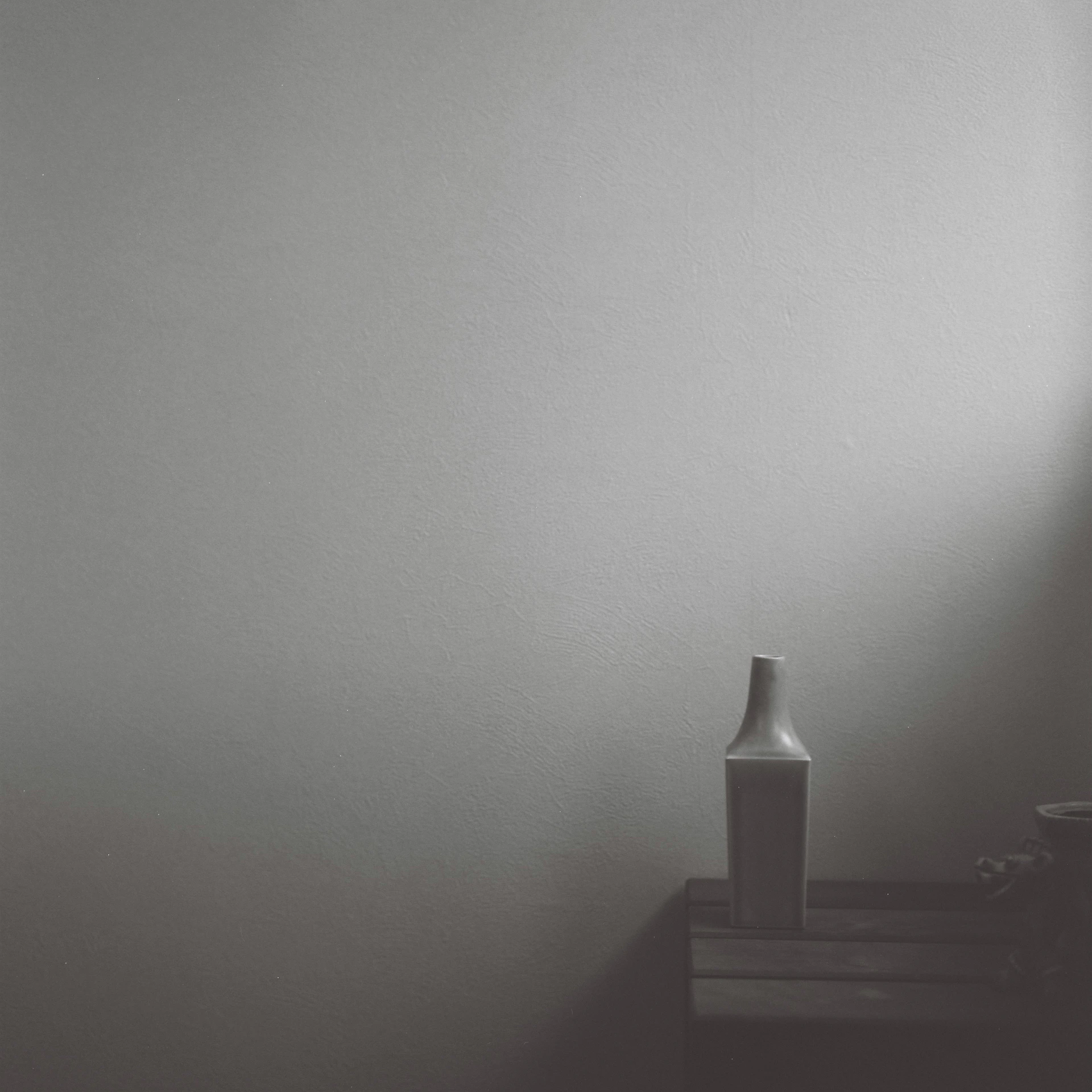 A minimalistic room corner featuring a custom handcrafted vase from Plantiq, blending seamlessly with the natural light and soft shadows.