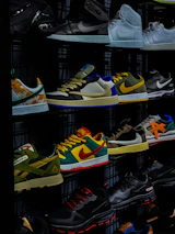 A lineup of premium sneakers displayed on a dark shelf with soft neon highlights.