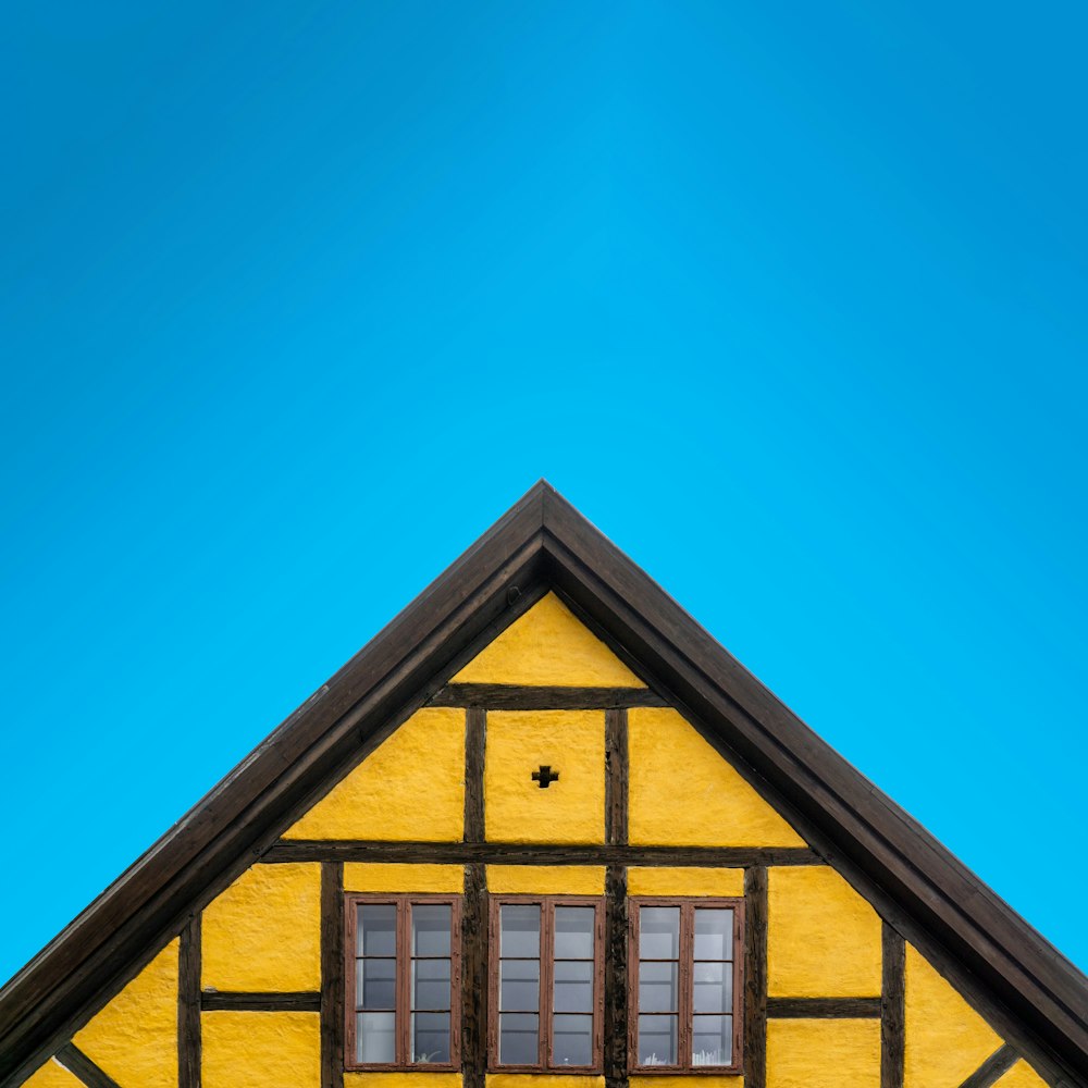 a yellow and black house with a blue sky in the background
