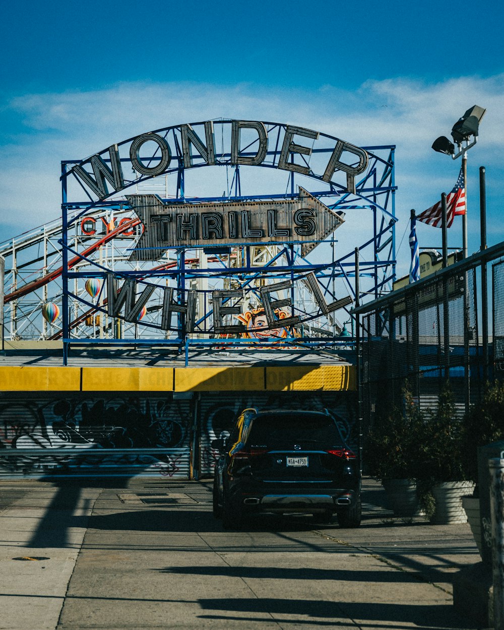 a car is driving under a carnival ride