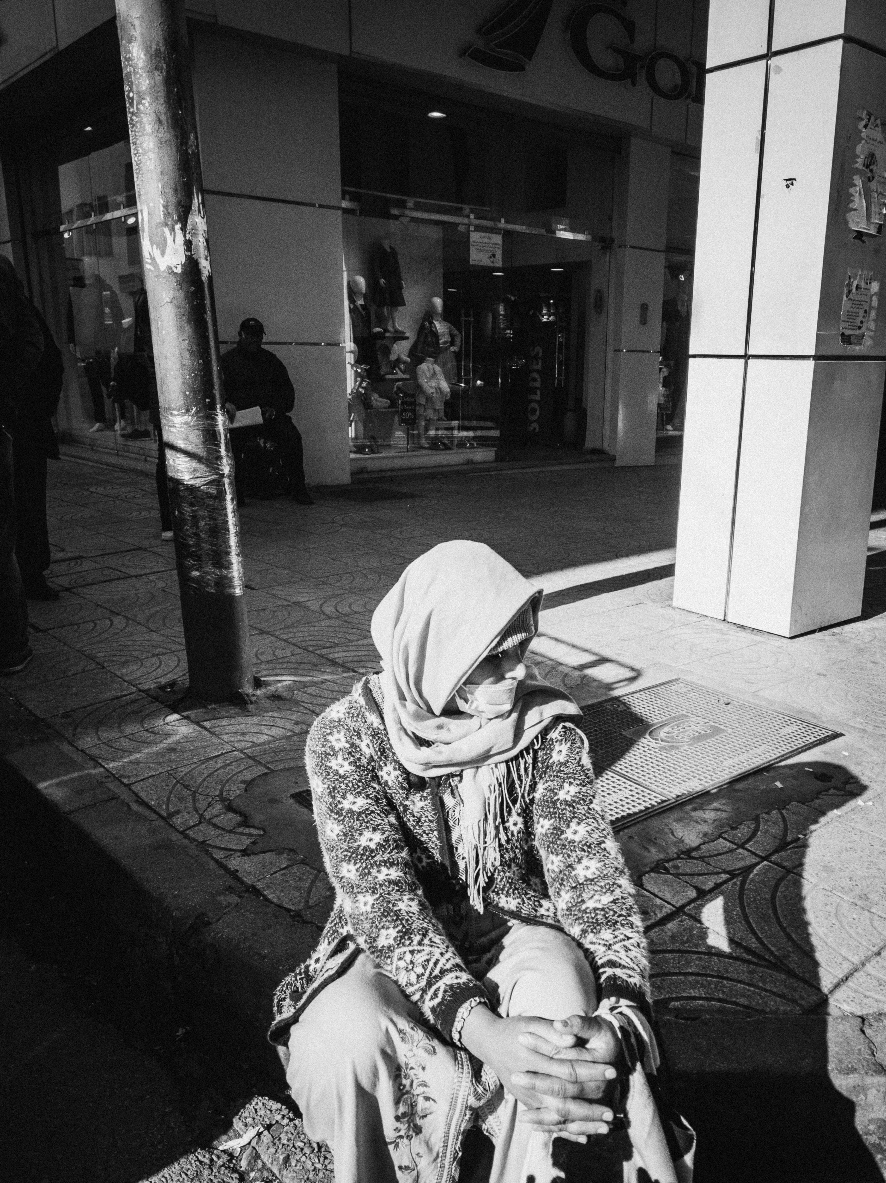 Une femme assise sur le trottoir avec son pied sur une planche à