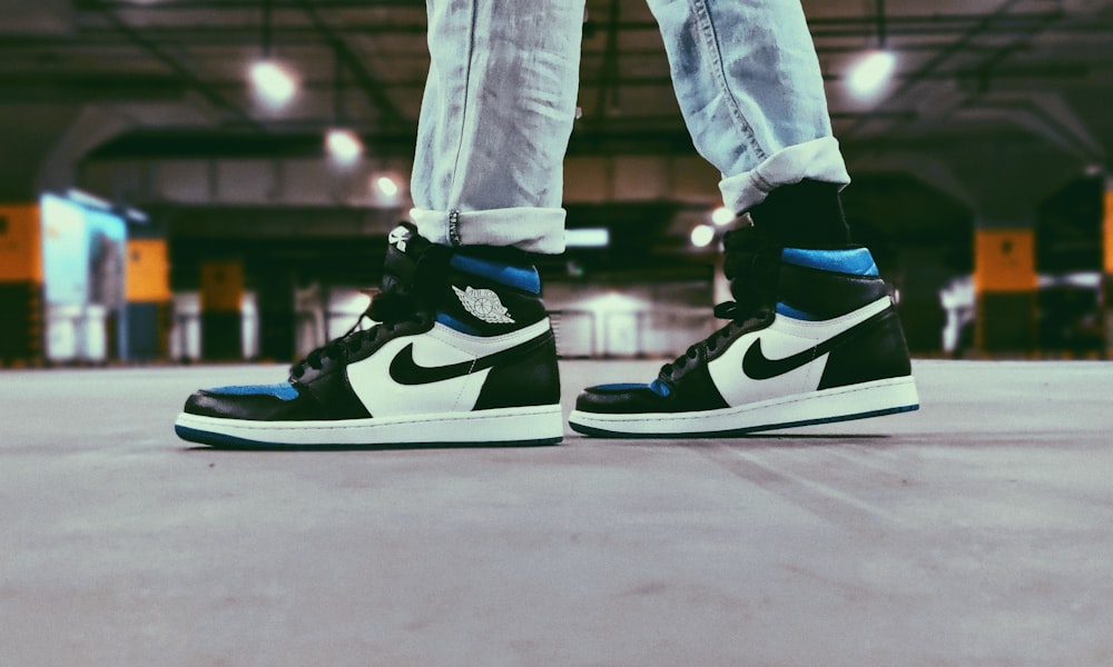 a pair of black and white sneakers with blue accents