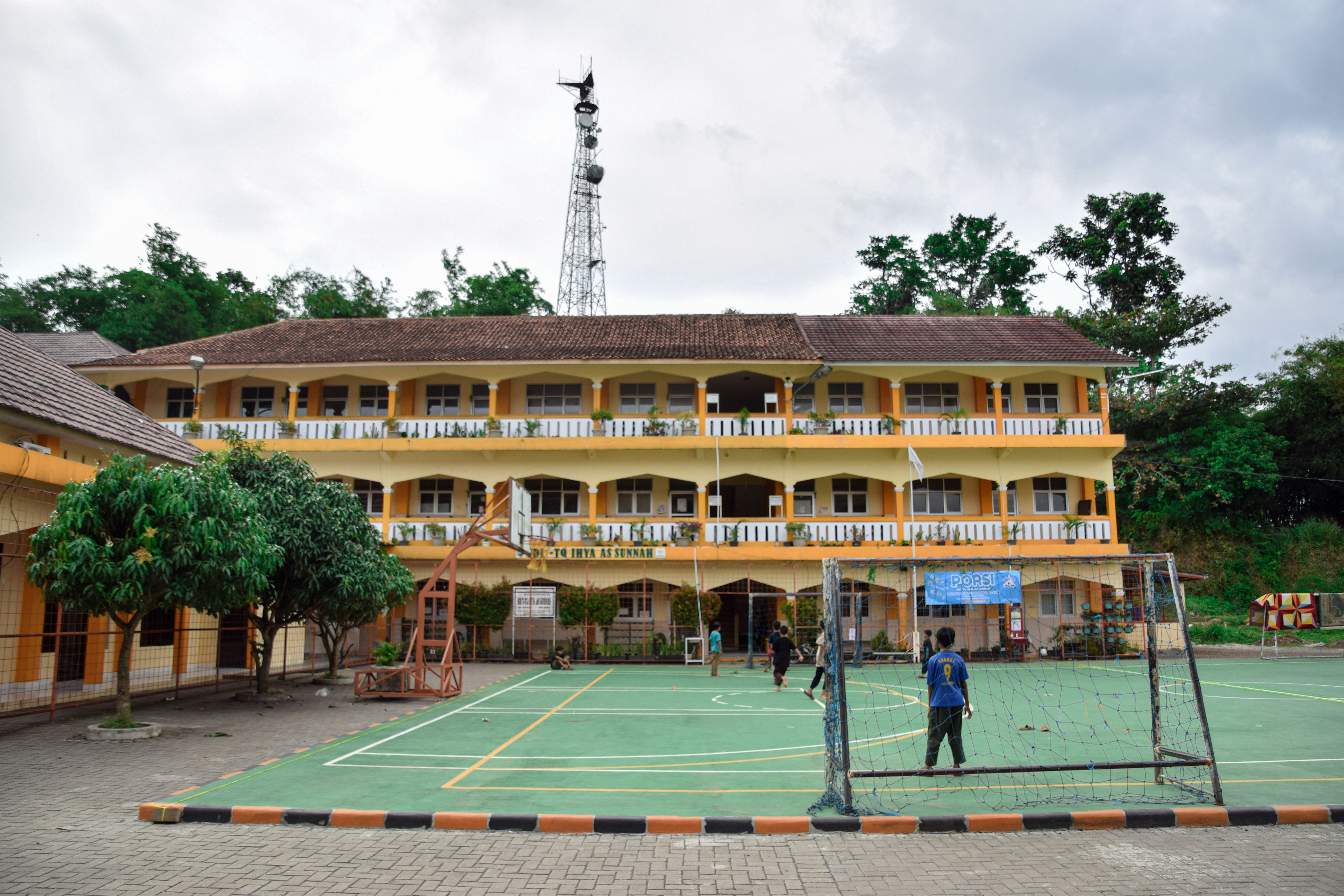 a man standing on a tennis court in front of a building