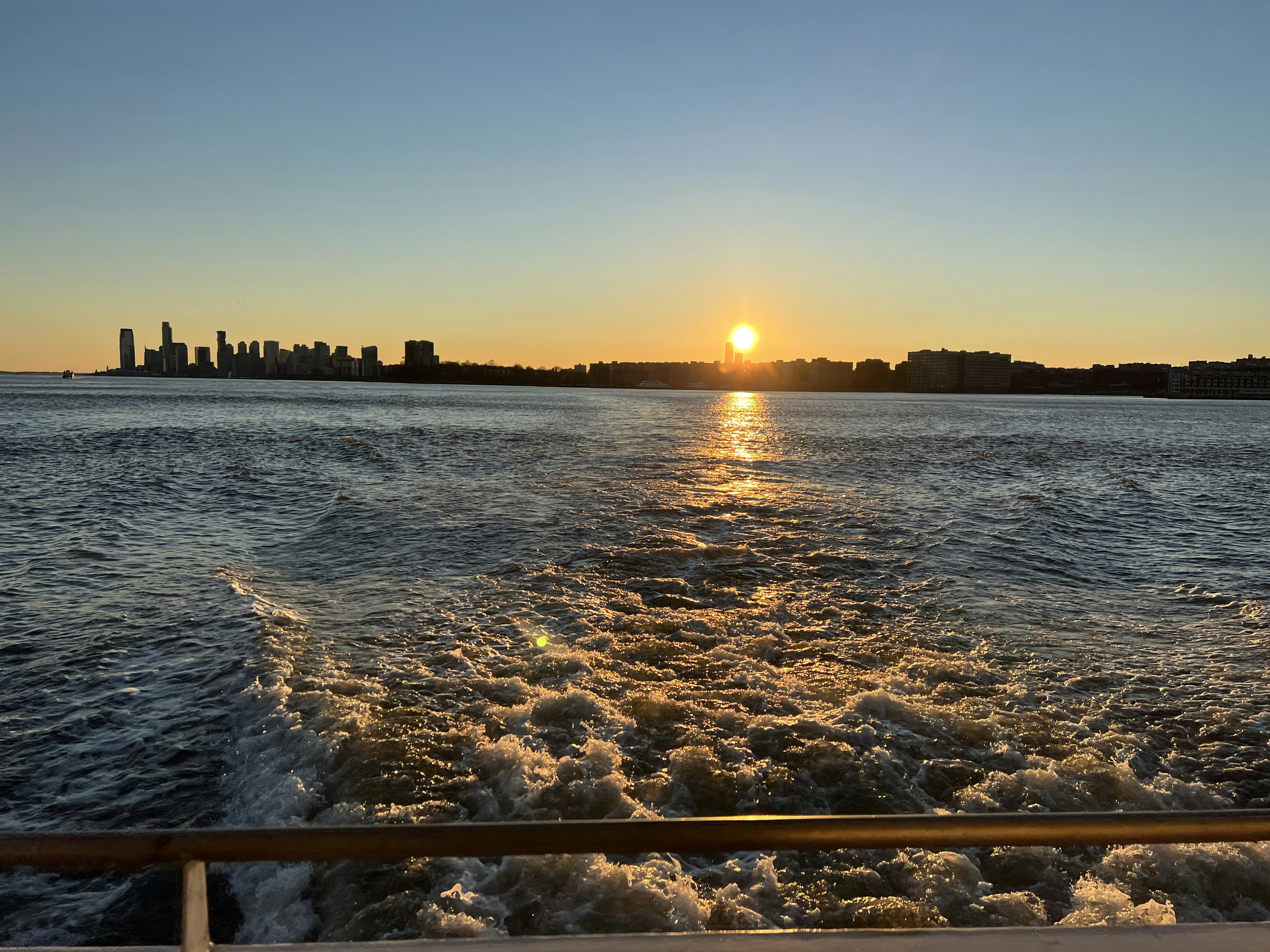 El sol se está poniendo sobre el agua visto desde un bote