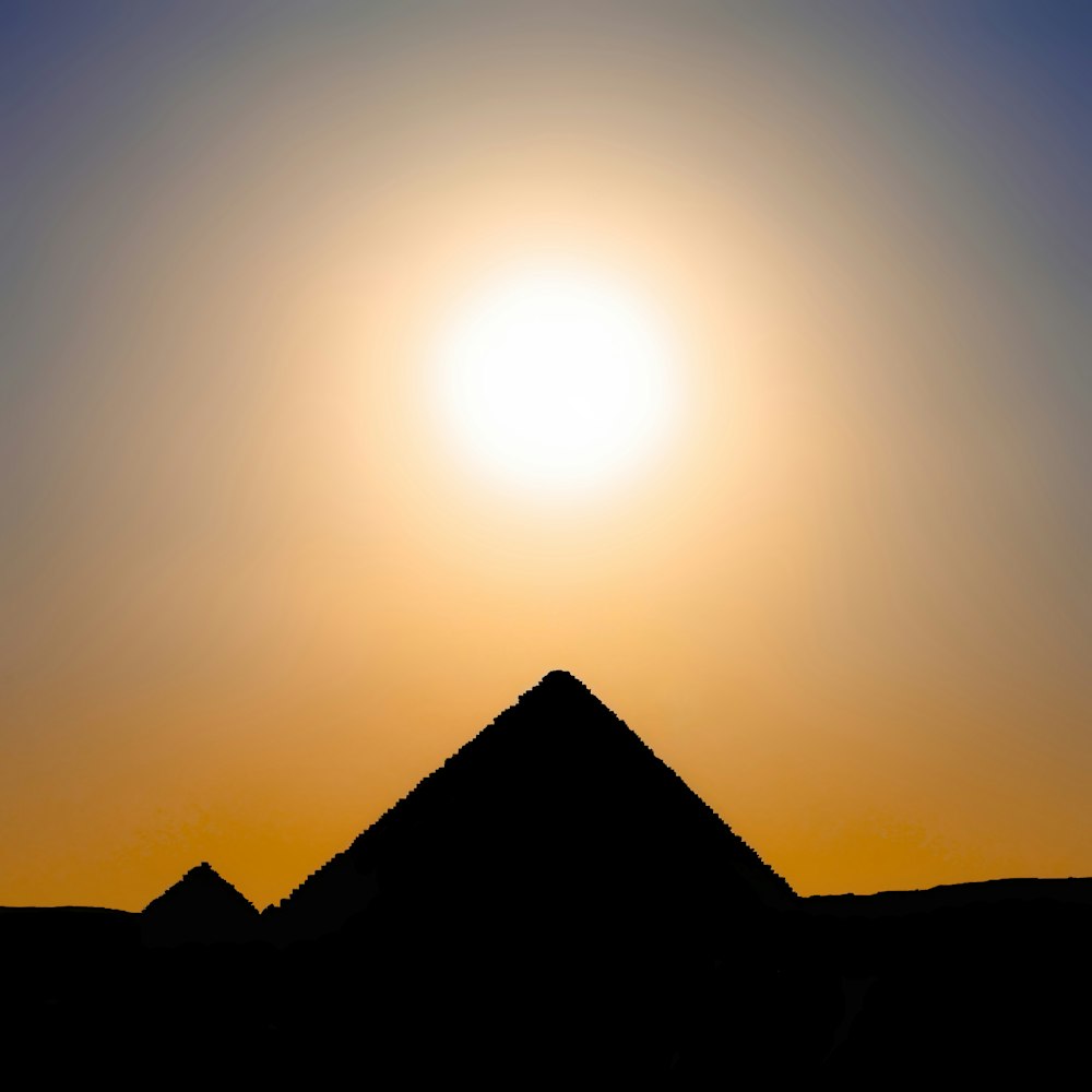 the sun is setting over the pyramids of giza