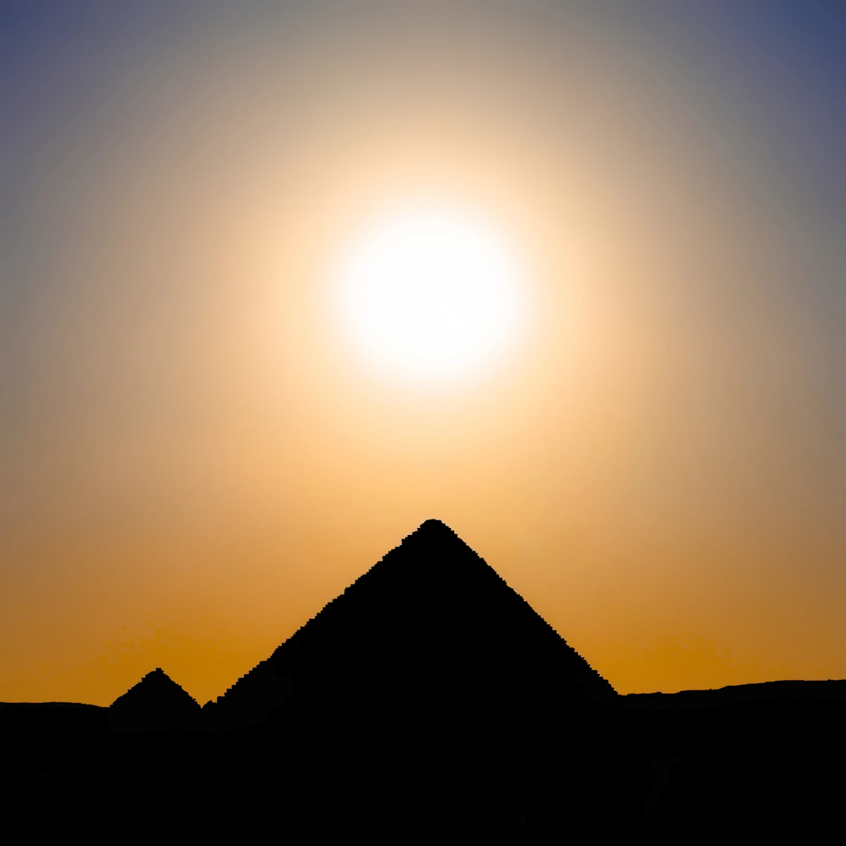 The sun setting over the pyramids of Giza