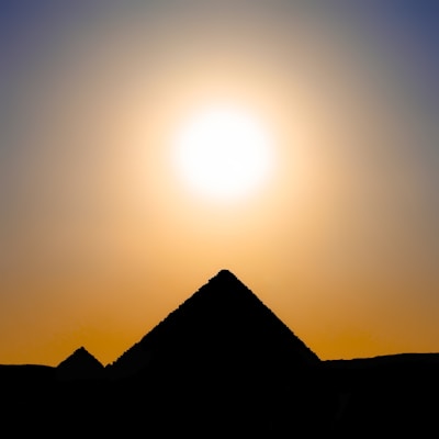 The Great Pyramids of Giza standing against a golden sunset sky