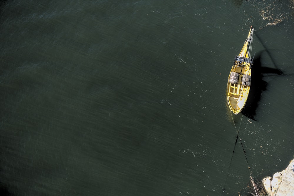 a yellow boat floating on top of a body of water