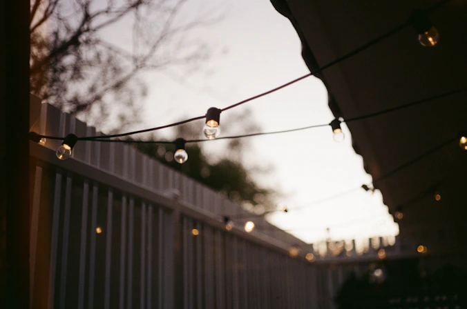 a string of lights hanging from a fence
