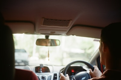 a person sitting in a car using a cell phone